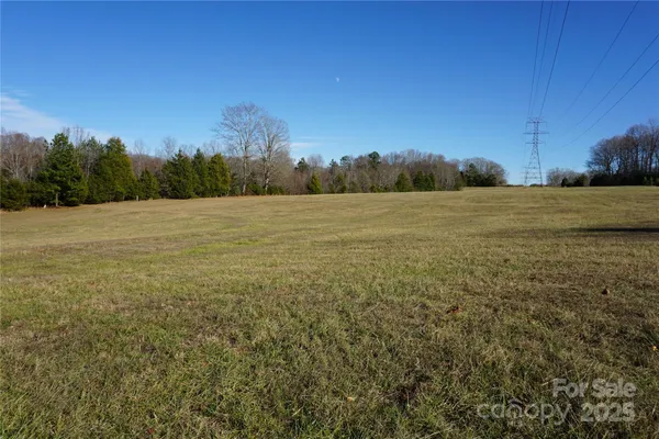 a view of a field with an ocean in background