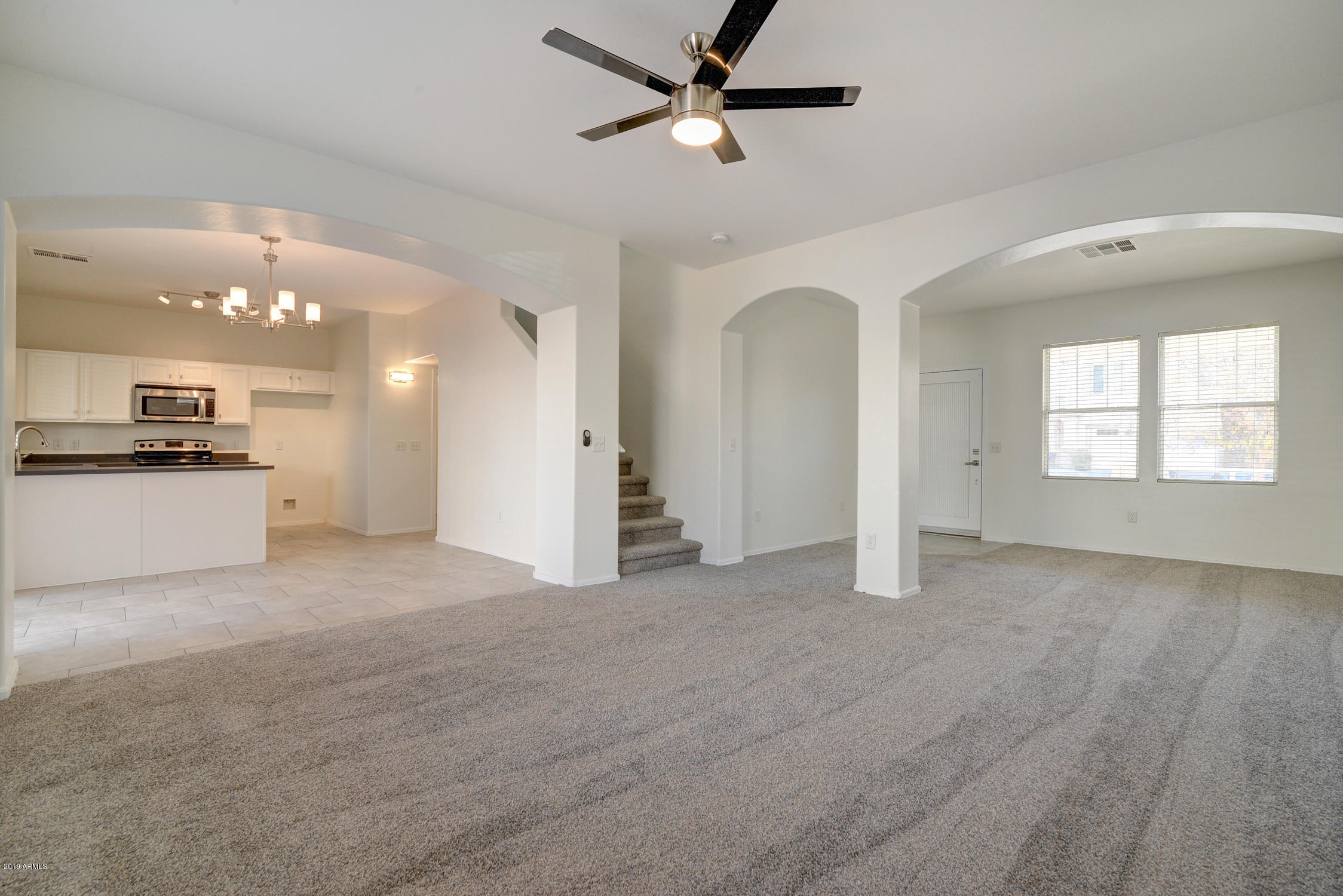 3918 West Carter Road Phoenix, AZ 85041 - Photo 8 of 33 a view of a big room with windows and chandelier fan