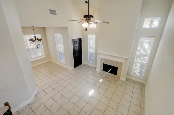 a view of an empty room and chandelier fan