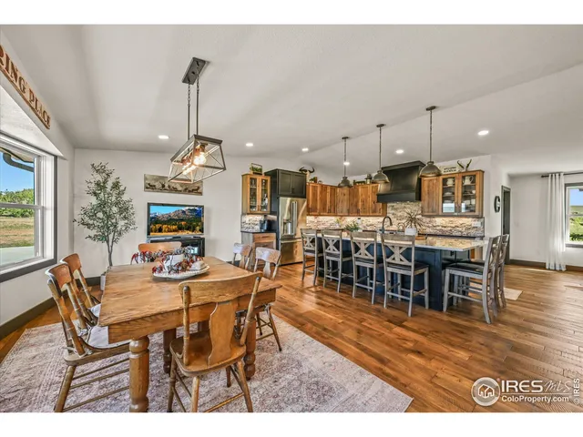 a kitchen with stainless steel appliances granite countertop a table chairs stove and cabinets
