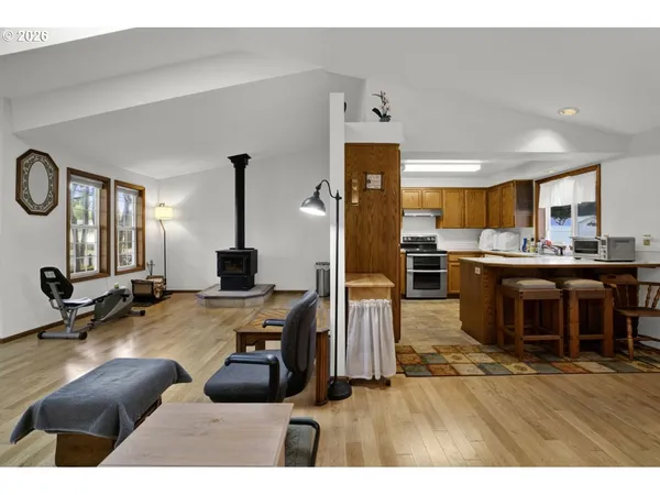 a living room with furniture a flat screen tv and kitchen view
