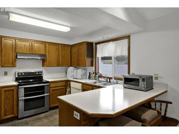 a kitchen with kitchen island a sink stove and refrigerator