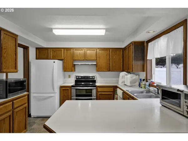a kitchen with granite countertop a refrigerator stove top oven and sink