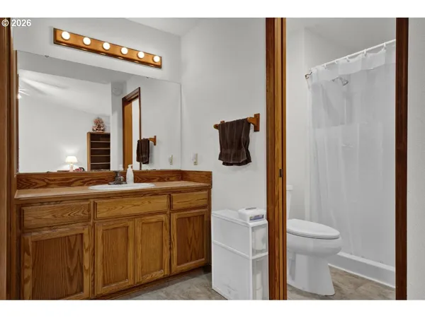 a bathroom with a granite countertop sink toilet and shower