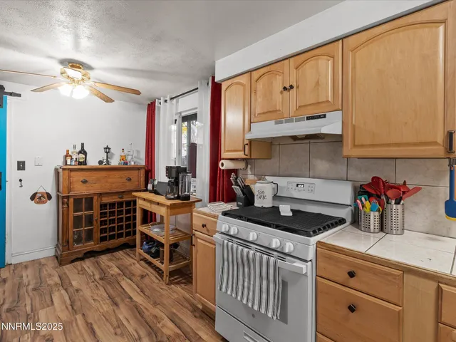 a kitchen with kitchen island granite countertop a stove and a wooden cabinets