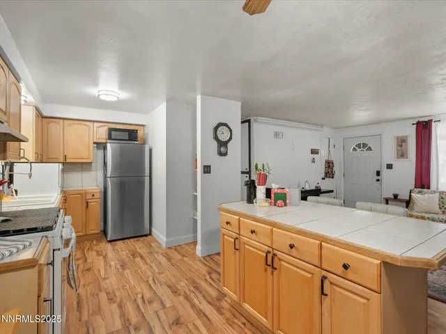 a view of a kitchen with a sink dishwasher refrigerator stove and wooden cabinets