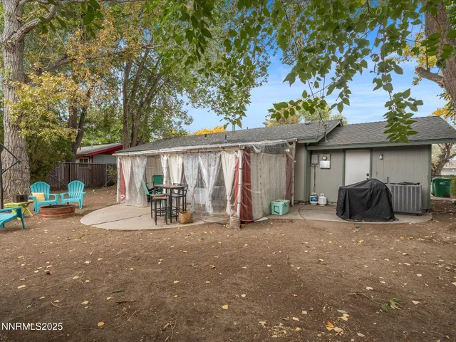 a view of a house with backyard and chairs