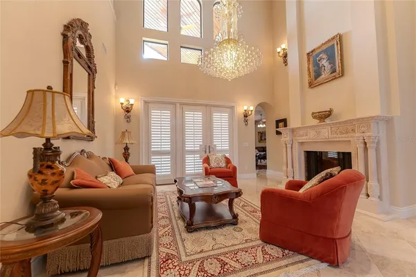 a living room with furniture a fireplace and a chandelier