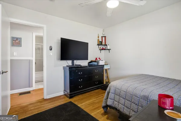 a bedroom with a bed and a flat tv screen on dresser