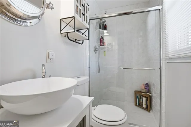a bathroom with a white toilet and shower