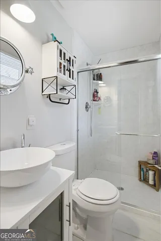 a bathroom with a sink a toilet and shower