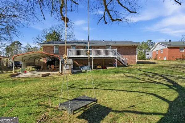a view of a house with a big yard and sitting area