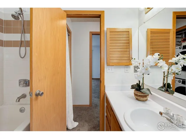 a bathroom with a granite countertop sink a mirror and shower