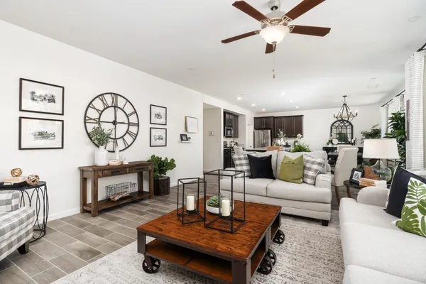 a kitchen with stainless steel appliances granite countertop a stove top oven a sink dishwasher a dining table and chairs with wooden floor