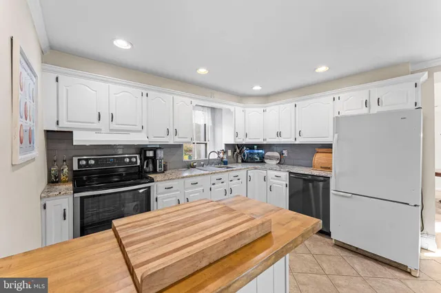 a kitchen with granite countertop a sink a stove and cabinets