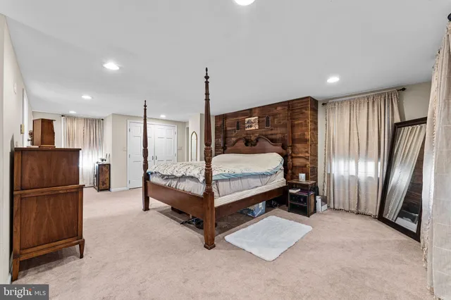 a spacious bedroom with a bed a couch and a dresser