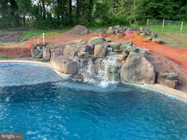 a kitchen with granite countertop a refrigerator a sink dishwasher a dining table and chairs with wooden floor