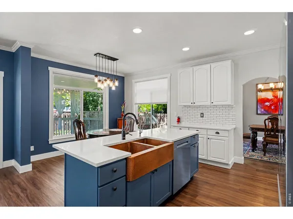 a kitchen with wooden cabinets a sink dishwasher and a stove with wooden floor