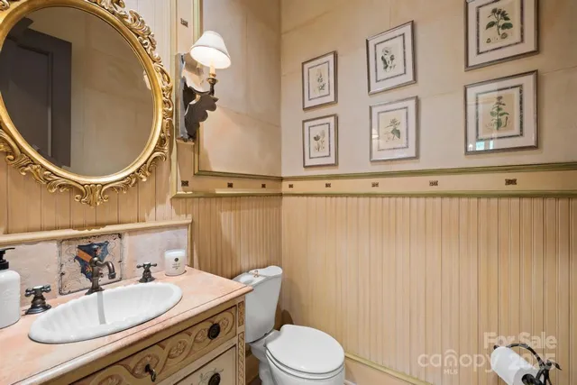 a bathroom with a granite countertop sink mirror vanity and toilet