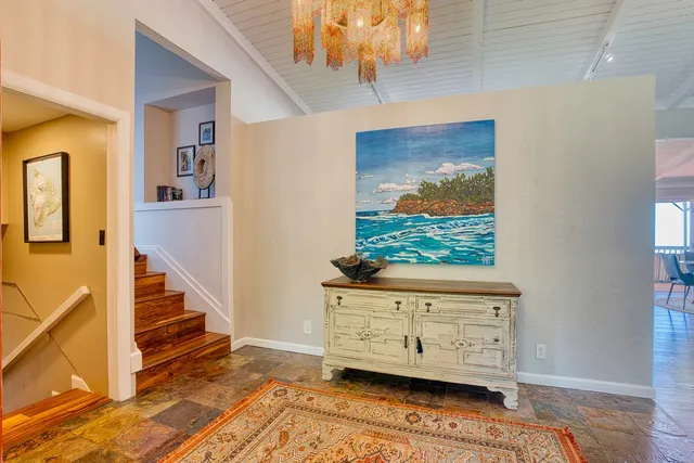 a view of a dining room with furniture a chandelier and wooden floor