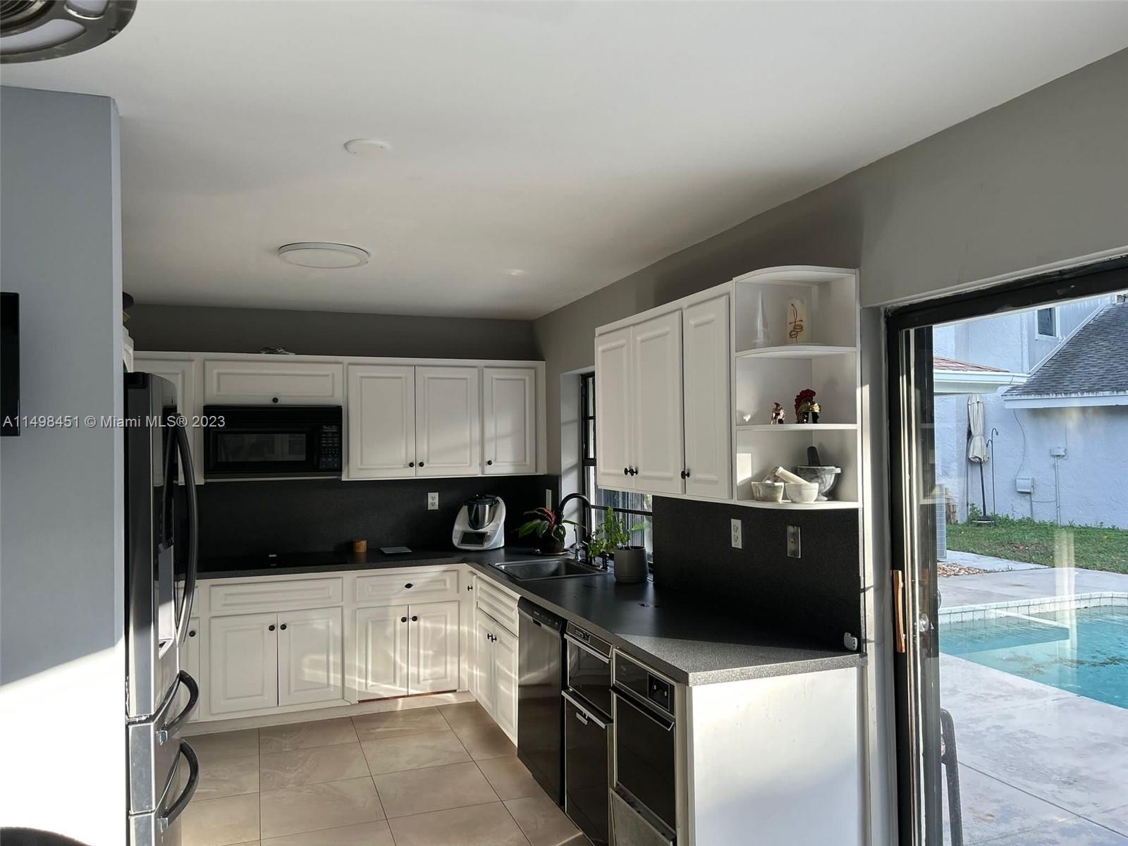 92 Juniper Road, Unit 92 Hollywood, FL 33021 - Photo 17 of 32 a kitchen with a refrigerator and a stove top oven