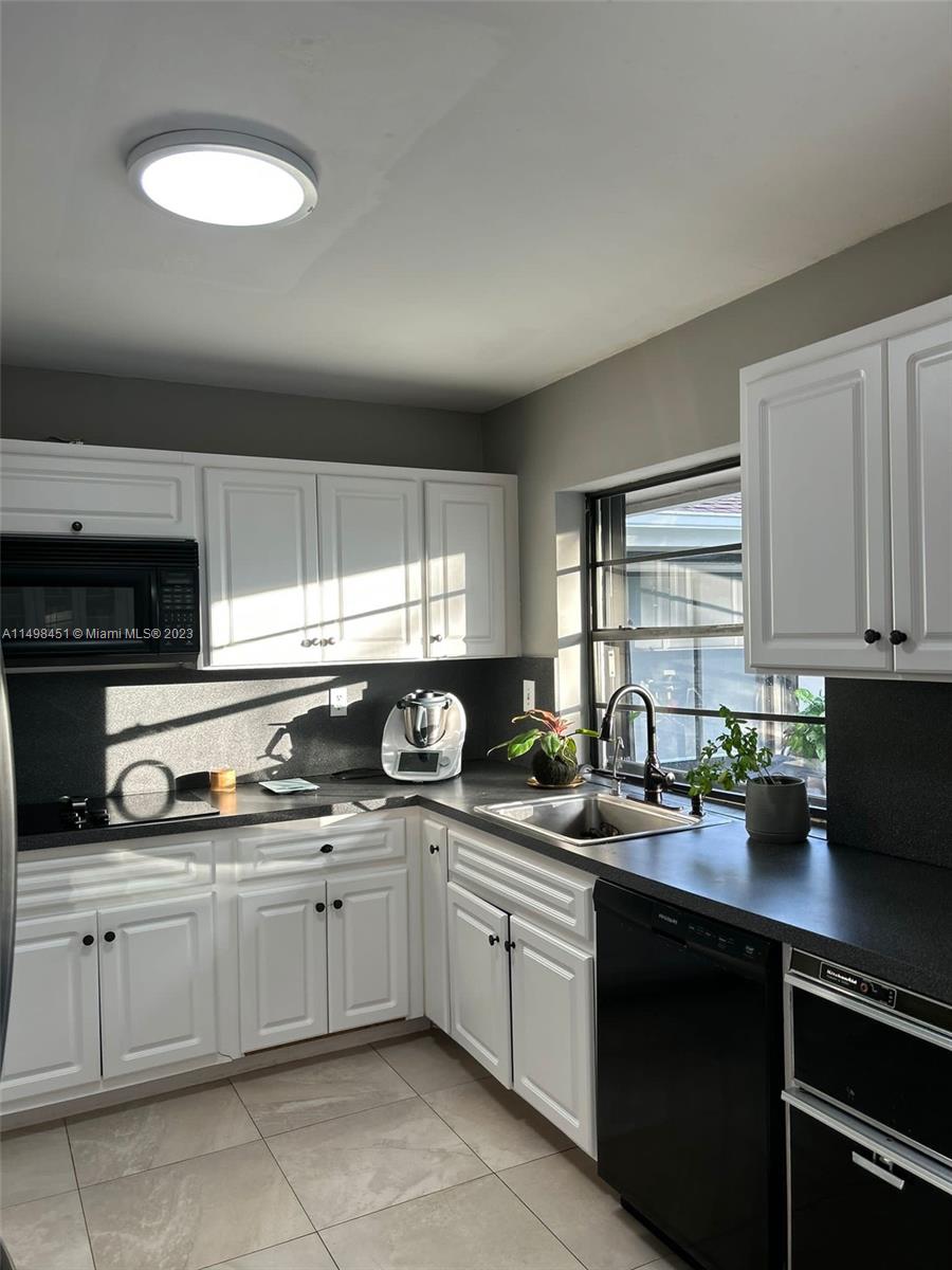 92 Juniper Road, Unit 92 Hollywood, FL 33021 - Photo 19 of 32 a kitchen with a sink a stove cabinets and a window