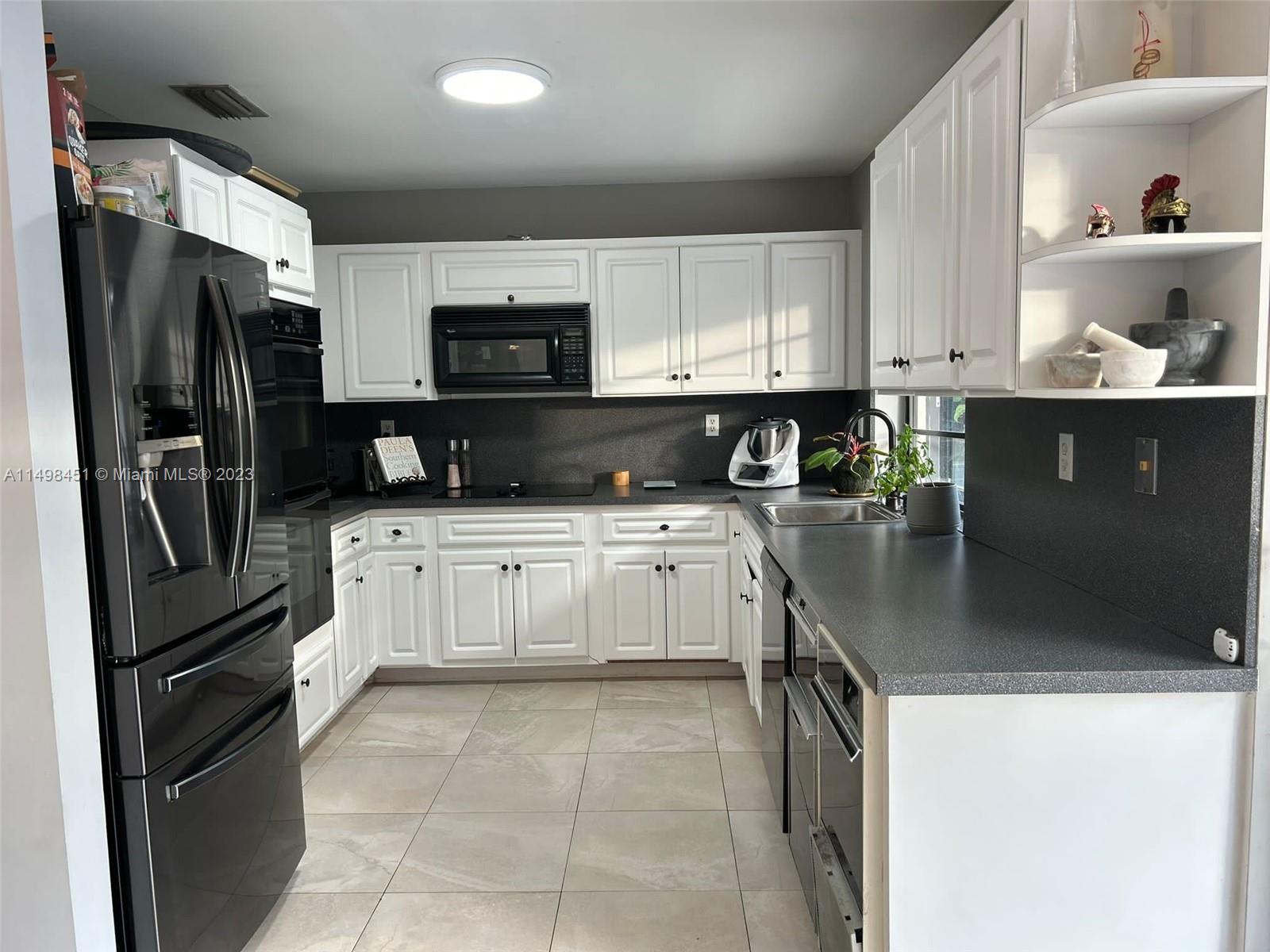 92 Juniper Road, Unit 92 Hollywood, FL 33021 - Photo 27 of 32 a kitchen with stainless steel appliances granite countertop a refrigerator sink and stove