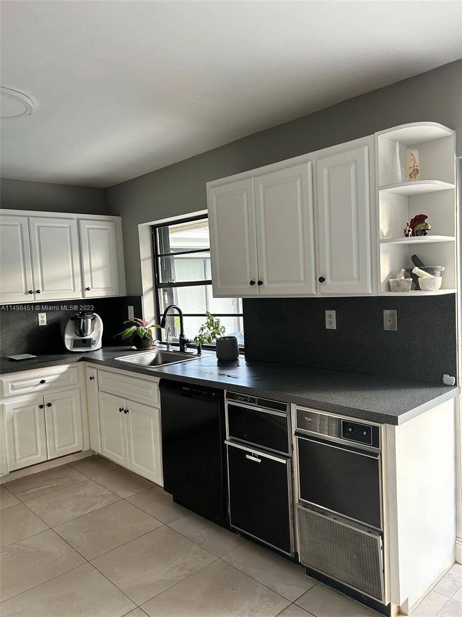 92 Juniper Road, Unit 92 Hollywood, FL 33021 - Photo 4 of 32 a kitchen with granite countertop white cabinets and appliances