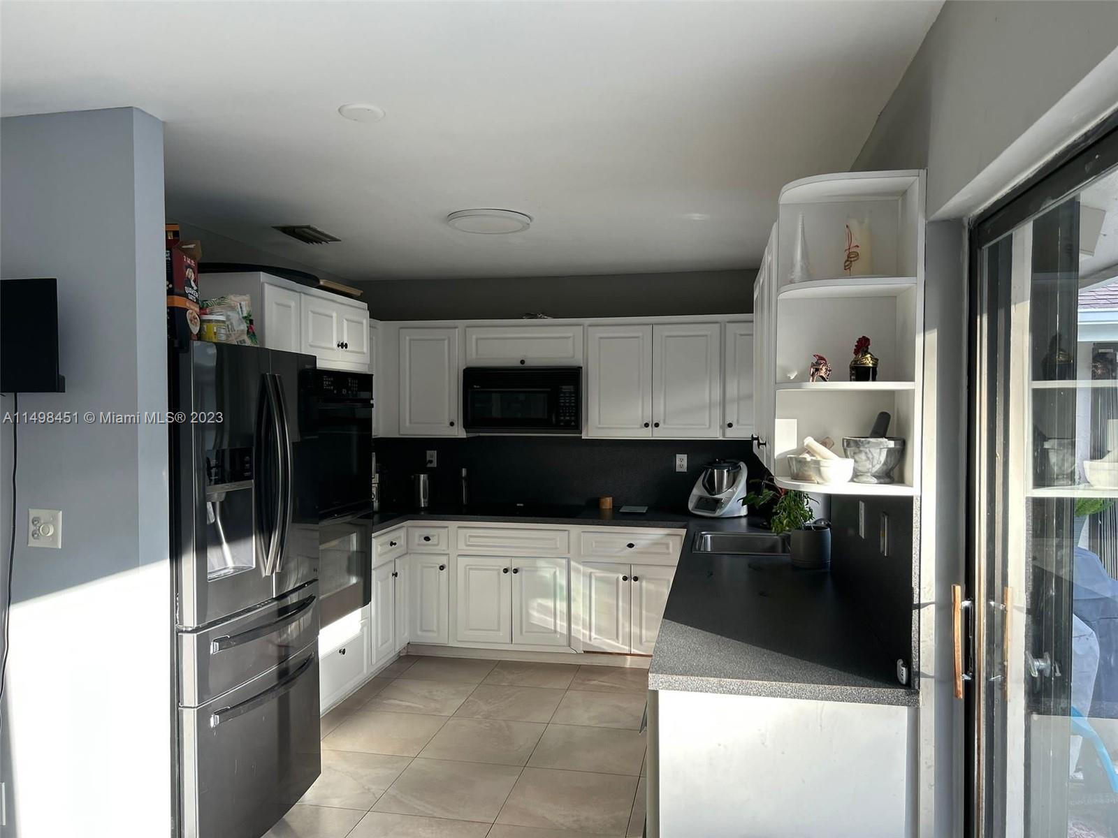 92 Juniper Road, Unit 92 Hollywood, FL 33021 - Photo 5 of 32 a kitchen with granite countertop a sink and cabinets