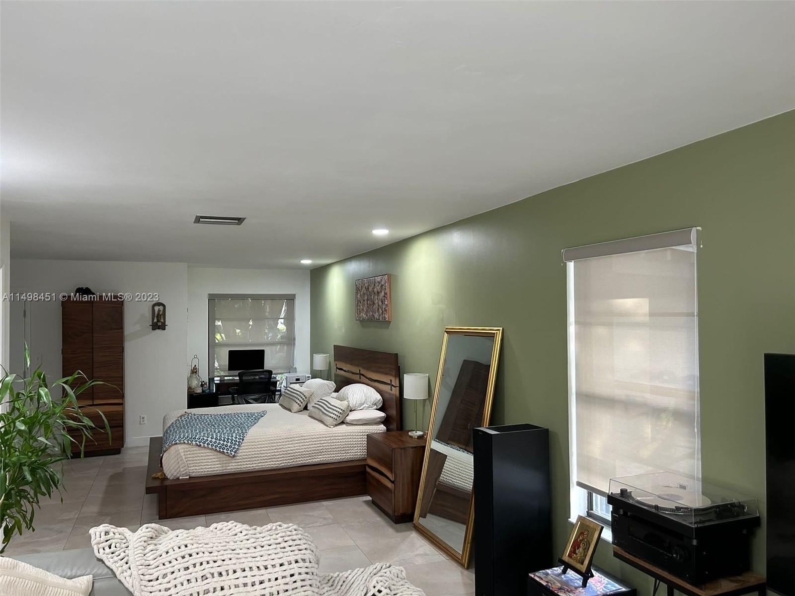 92 Juniper Road, Unit 92 Hollywood, FL 33021 - Photo 10 of 32 a bedroom with furniture and a flat screen tv