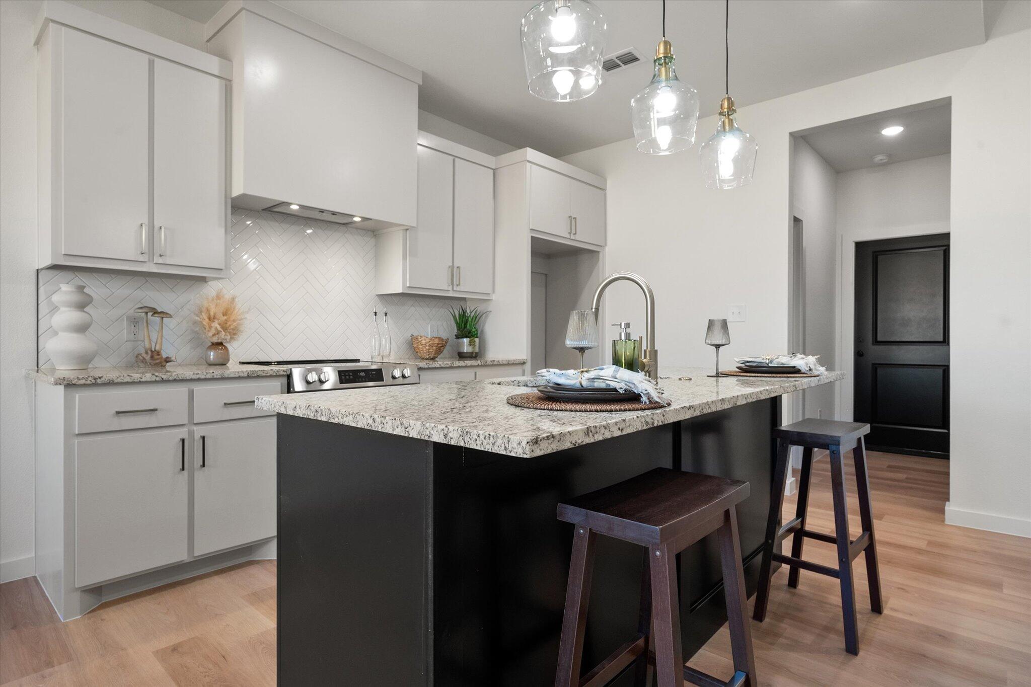 6928 14th Street Lubbock, TX 79416 - Photo 12 of 33 a kitchen with granite countertop a sink a center island stainless steel appliances and cabinets