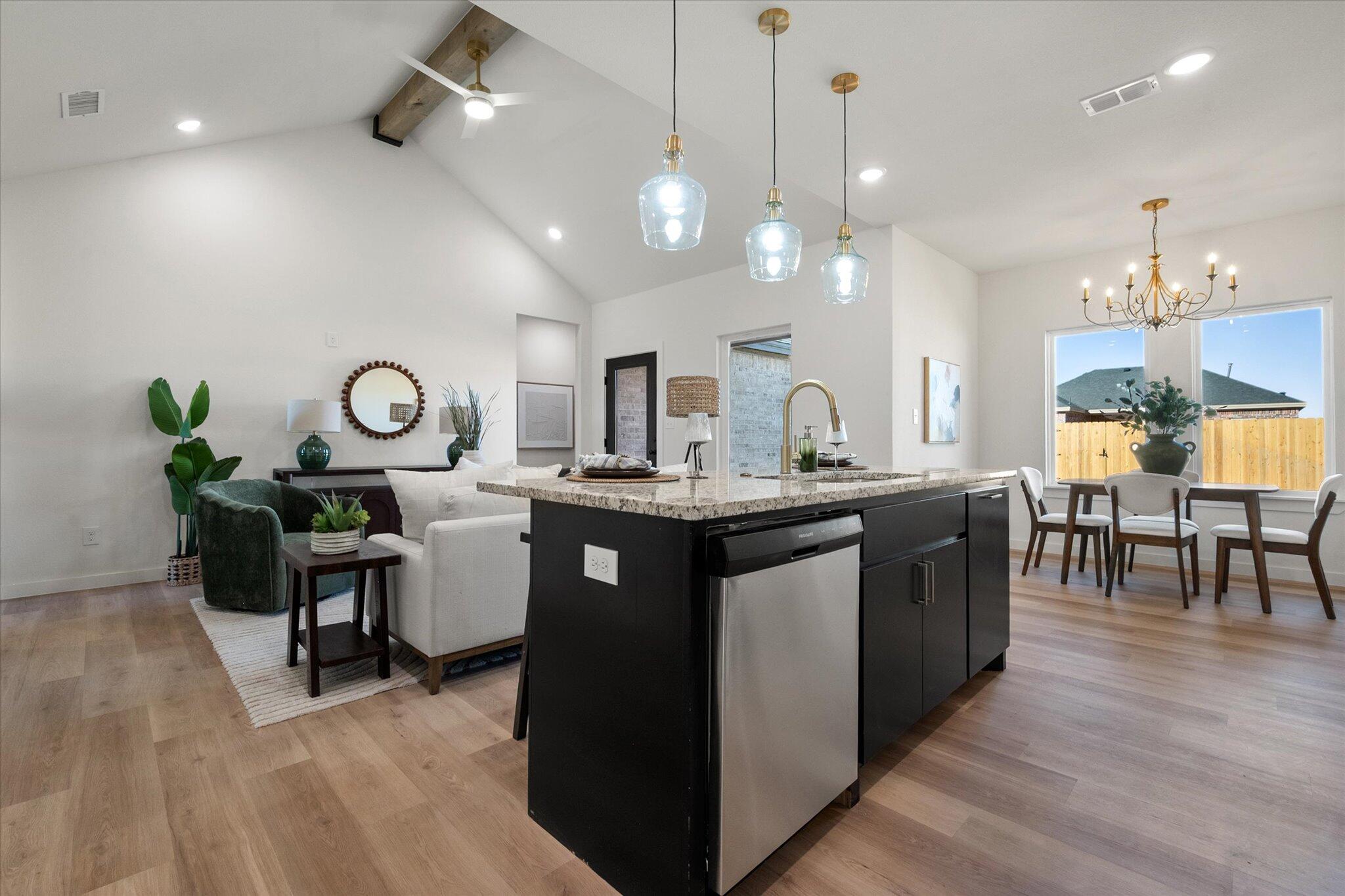 6928 14th Street Lubbock, TX 79416 - Photo 15 of 33 a kitchen with a counter space a sink appliances and a living room view