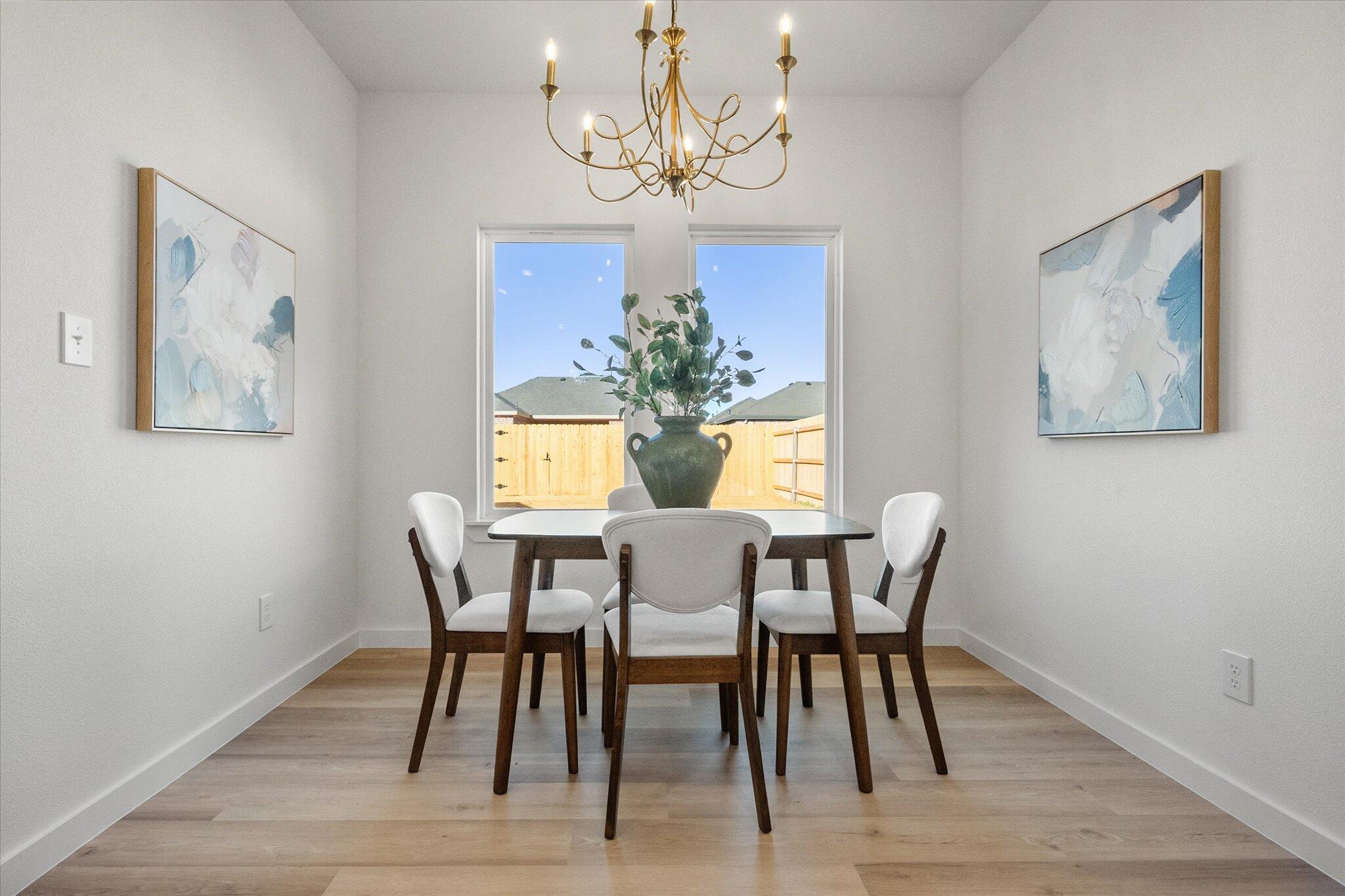 6928 14th Street Lubbock, TX 79416 - Photo 16 of 33 a view of a dining room with furniture wooden floor and a chandelier