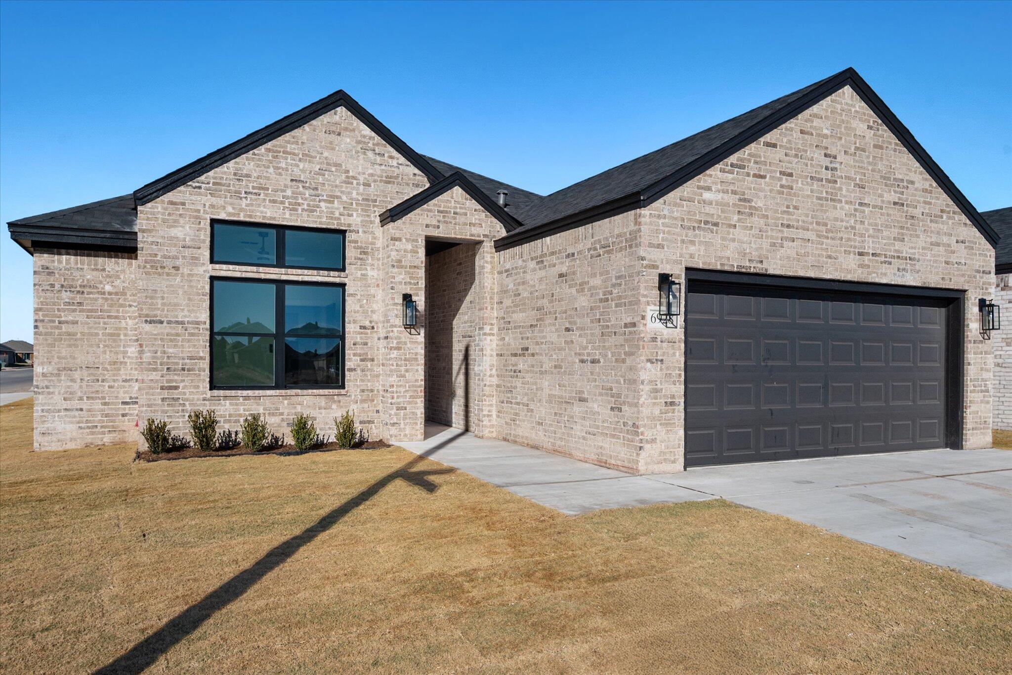 6928 14th Street Lubbock, TX 79416 - Photo 2 of 33 a front view of a house with a yard