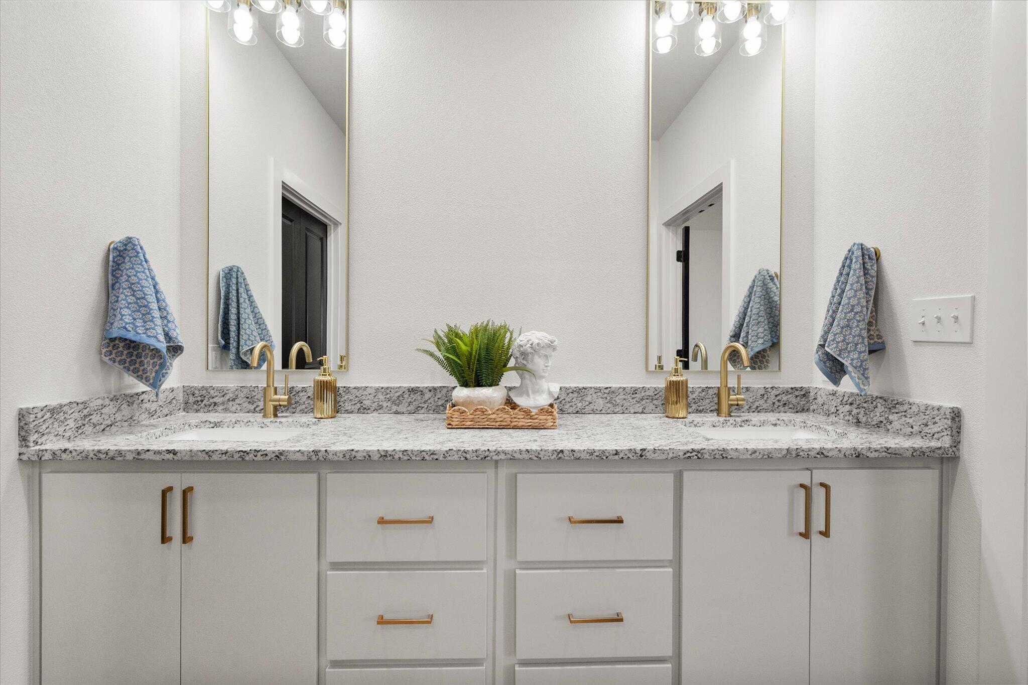 6928 14th Street Lubbock, TX 79416 - Photo 21 of 33 a bathroom with a granite countertop sink and a mirror
