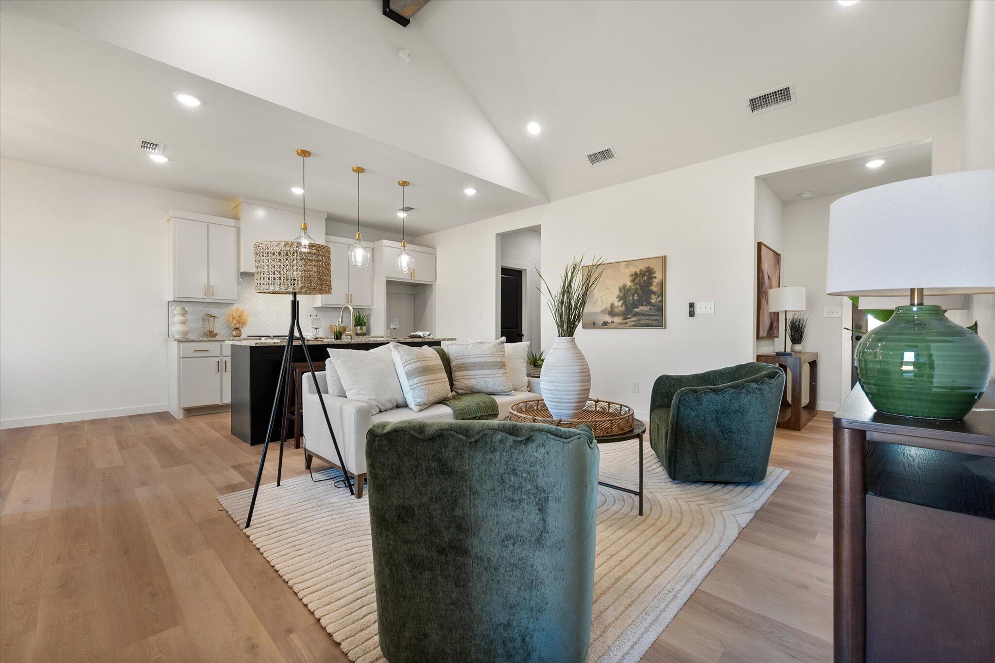 6928 14th Street Lubbock, TX 79416 - Photo 9 of 33 a living room with furniture a wooden floor and kitchen view