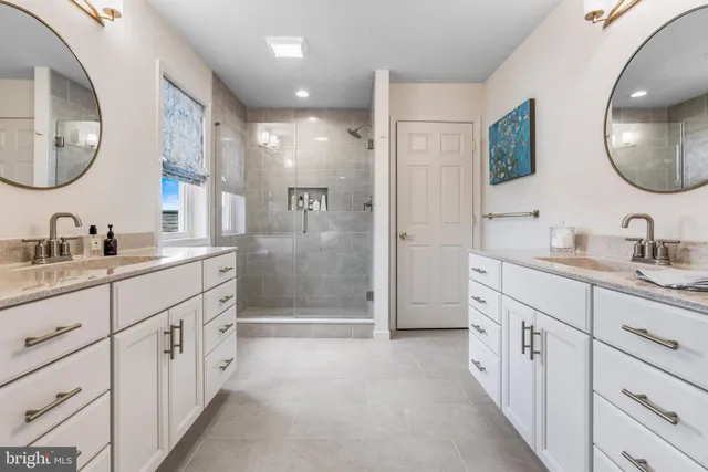 a spacious bathroom with a double vanity sink a mirror a bathtub and a shower