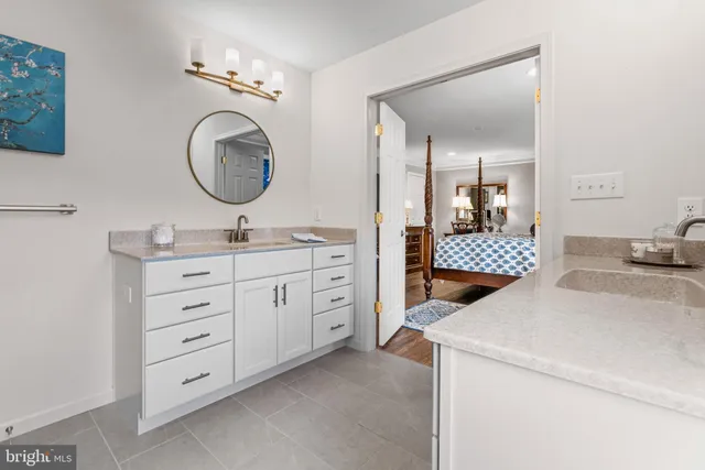 a room with a baby bed and a mirror