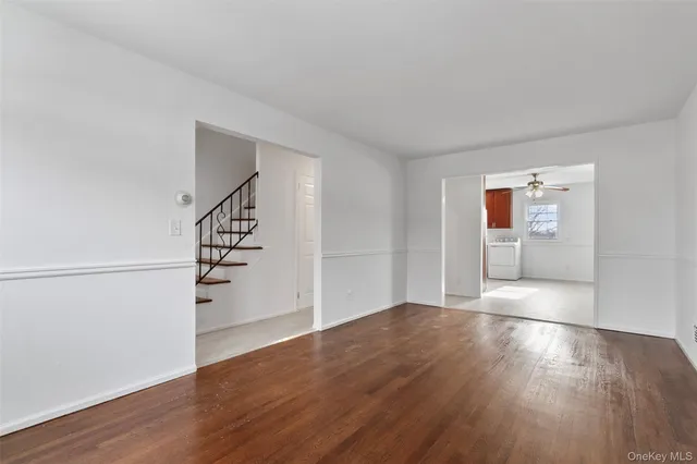 an empty room with wooden floor and entryway