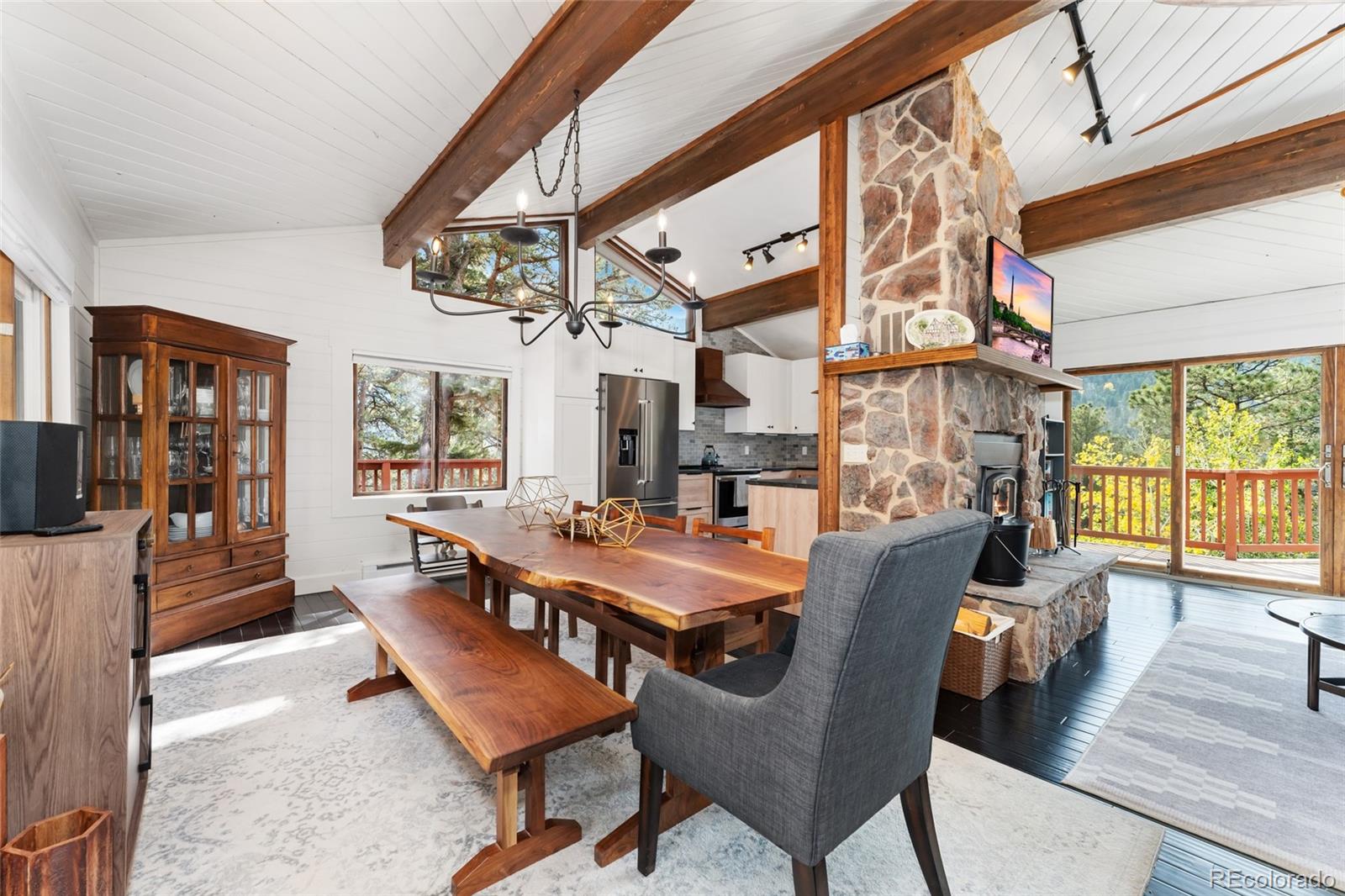 24333 Bent Feather Road Conifer, CO 80433 - Photo 11 of 50 a dining room with furniture a chandelier and wooden floor