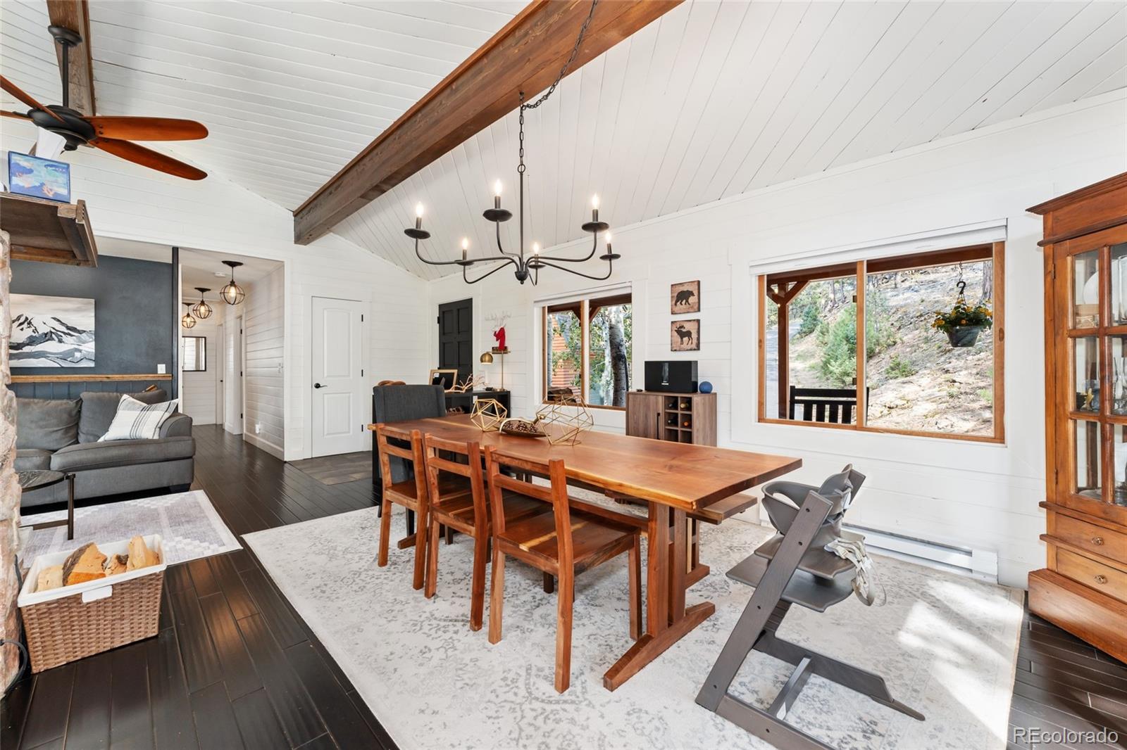 24333 Bent Feather Road Conifer, CO 80433 - Photo 12 of 50 a view of a dining room with furniture a chandelier and wooden floor