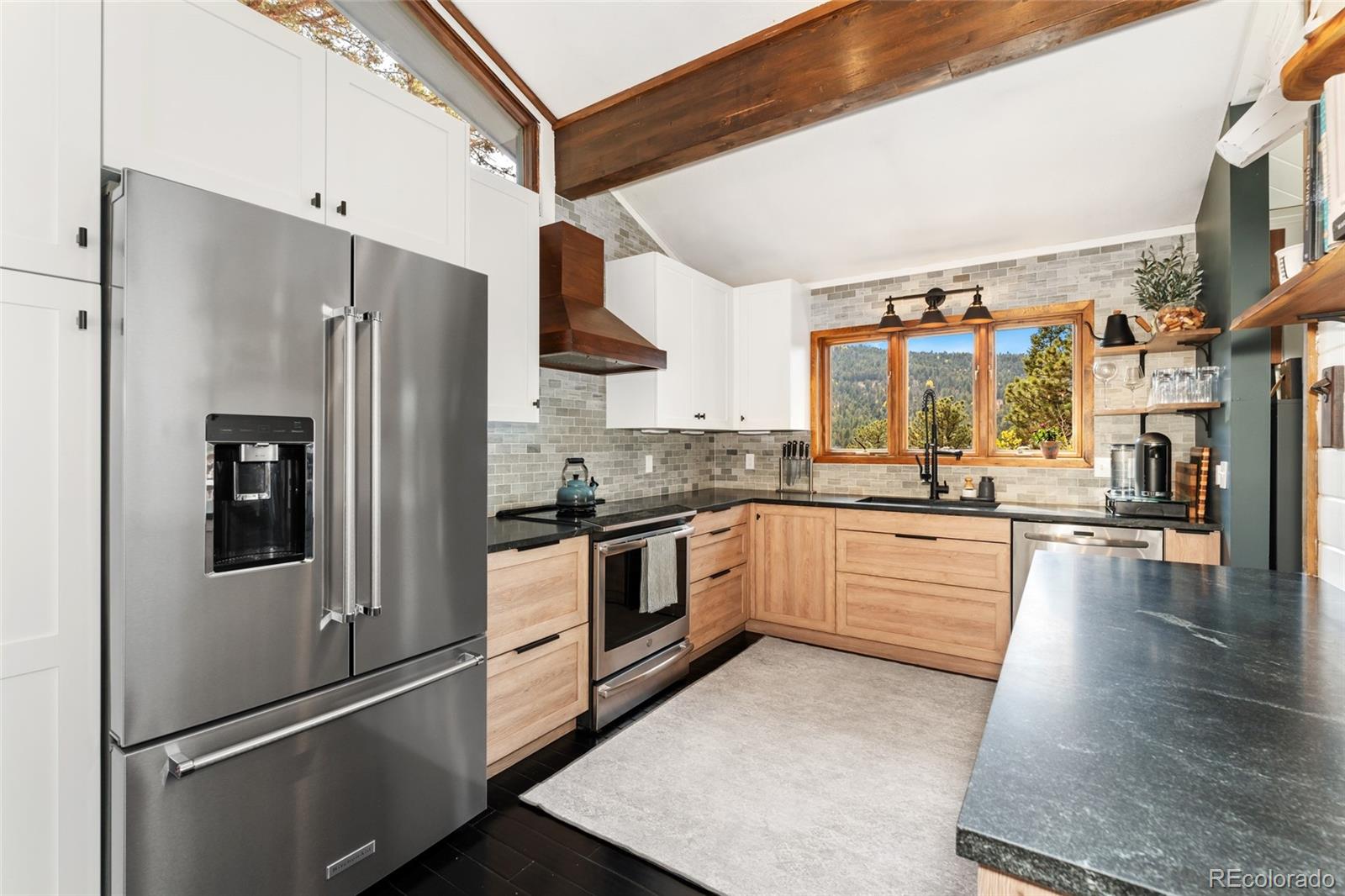 24333 Bent Feather Road Conifer, CO 80433 - Photo 14 of 50 a kitchen with stainless steel appliances a refrigerator sink and stove