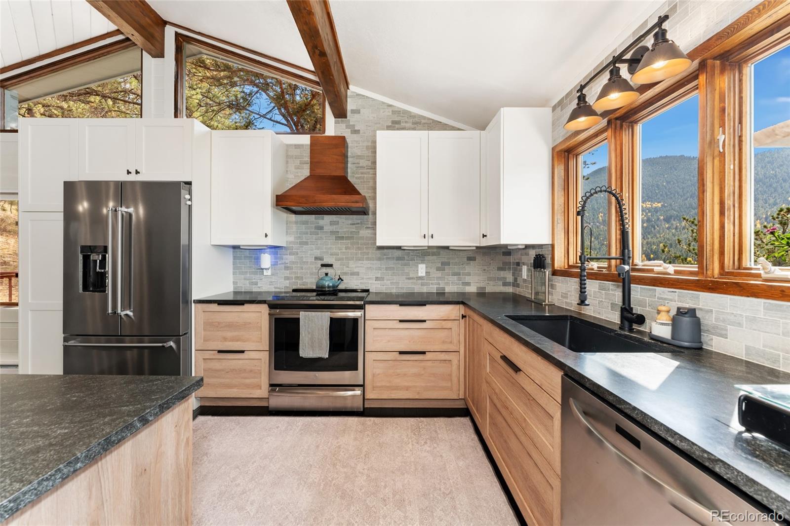 24333 Bent Feather Road Conifer, CO 80433 - Photo 16 of 50 a kitchen with stainless steel appliances granite countertop a sink stove and refrigerator