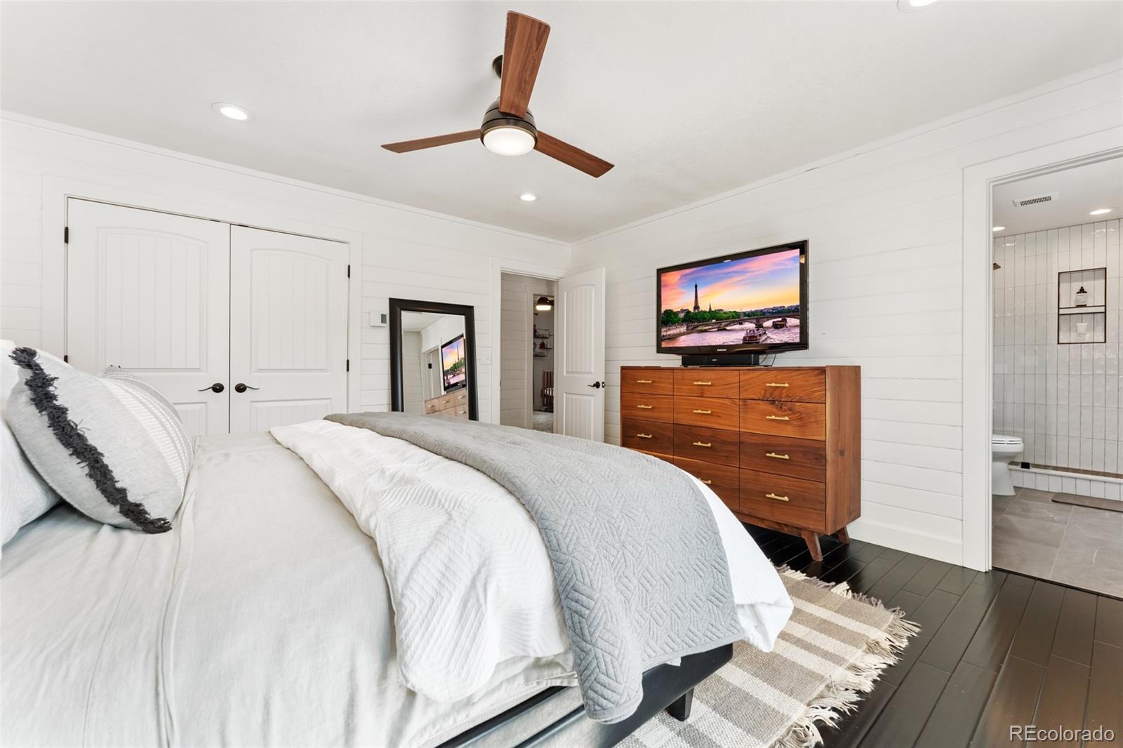 24333 Bent Feather Road Conifer, CO 80433 - Photo 20 of 50 a spacious bedroom with a bed and a flat screen tv