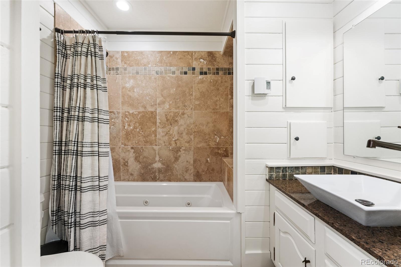 24333 Bent Feather Road Conifer, CO 80433 - Photo 25 of 50 a bathroom with a granite countertop sink a toilet and shower