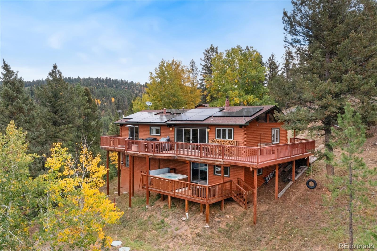 24333 Bent Feather Road Conifer, CO 80433 - Photo 44 of 50 a wooden house with a large trees and wooden fence