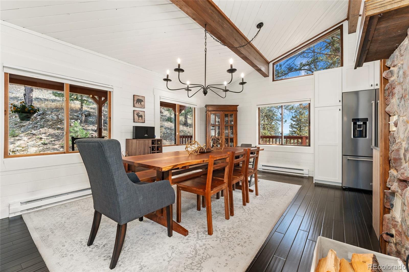 24333 Bent Feather Road Conifer, CO 80433 - Photo 10 of 50 a view of a dining room with furniture window and wooden floor