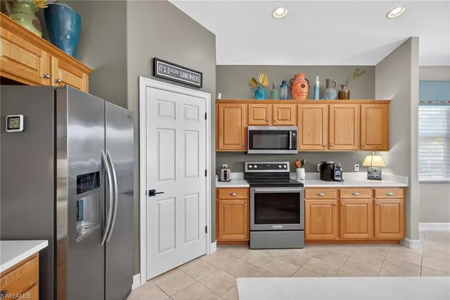 a kitchen with stainless steel appliances granite countertop a refrigerator a stove and a sink