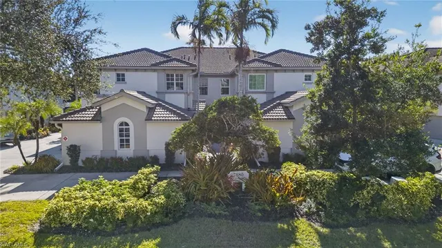 a front view of a house with a yard and a garden