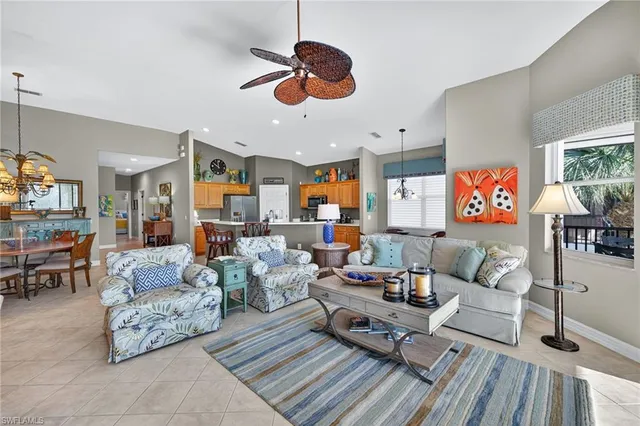 a living room with furniture kitchen view and a chandelier